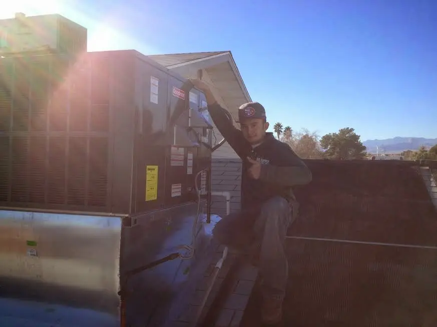 HVAC technician performing Air Duct Repair on a rooftop unit in Barberton